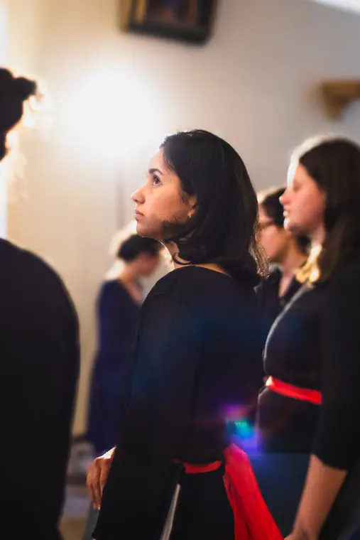 Des choristes chantant dans une église, partition en main