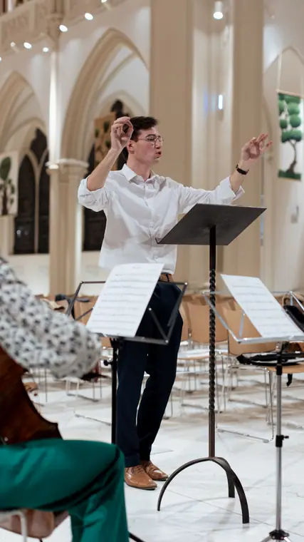 Paul Couturier dirigeant une répétition à la chapelle de la Catho