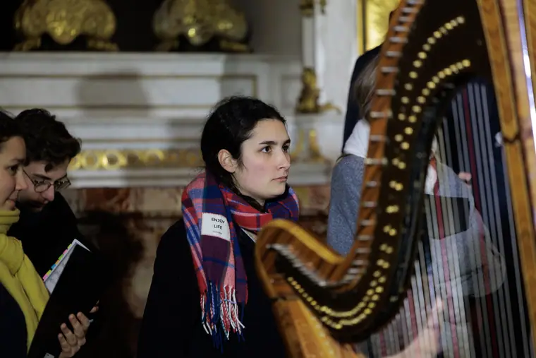 Une harpiste et des musiciens en répétition avec le chœur