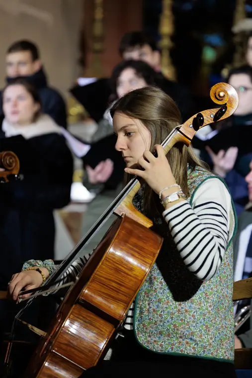 Une violoncelliste en répétition avec le chœur